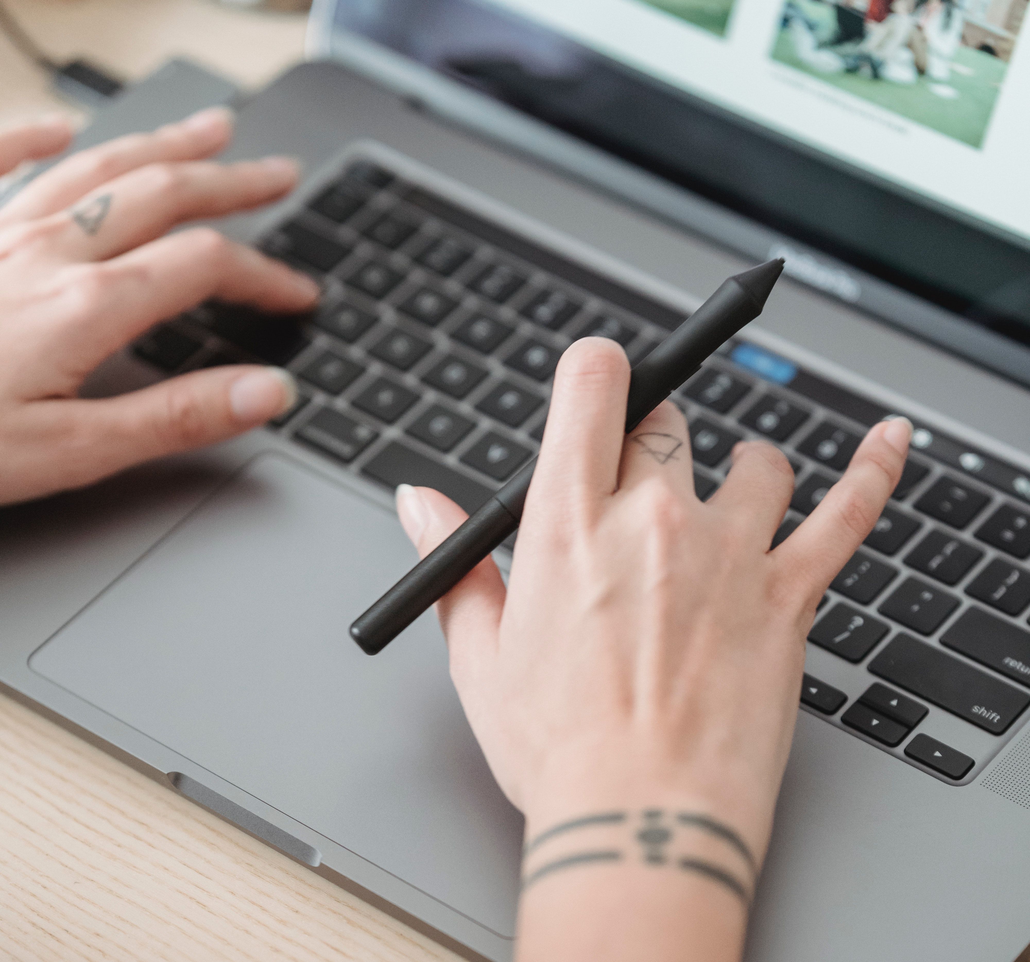 hands typing on a macbook keyboard