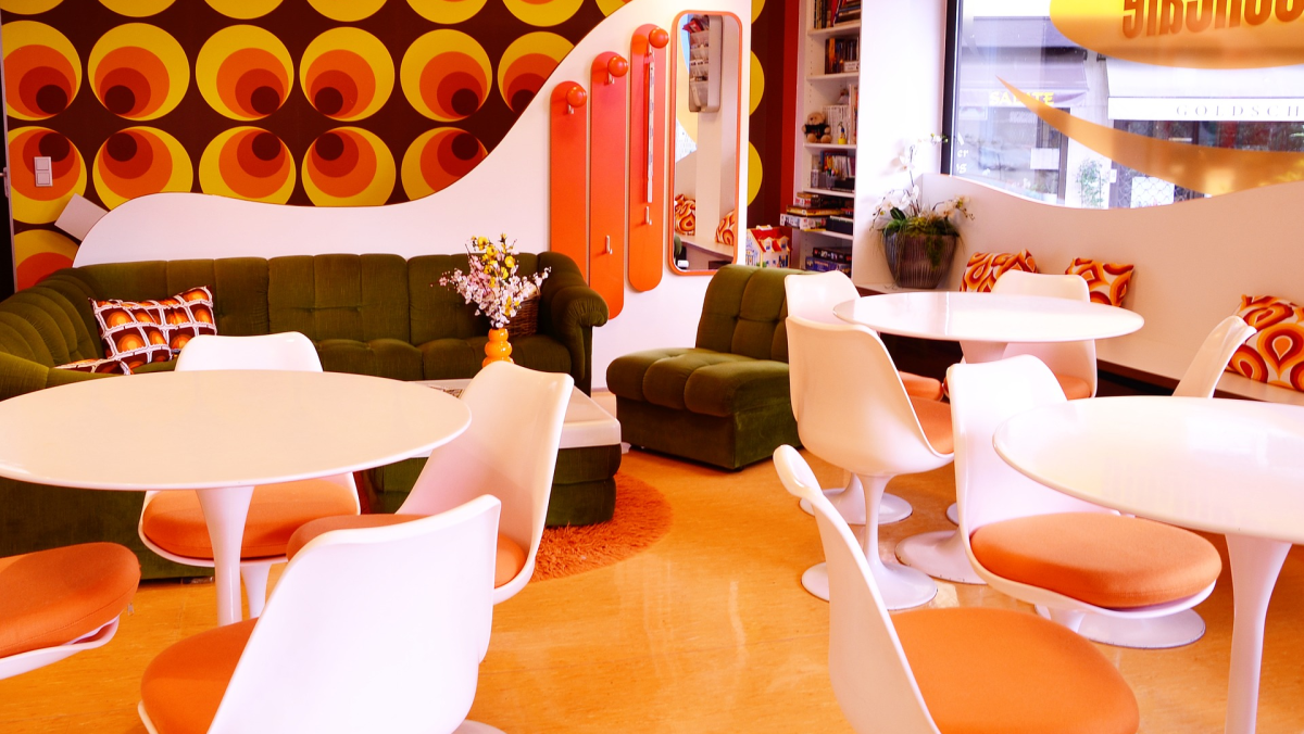 A room with tulip chairs and tables